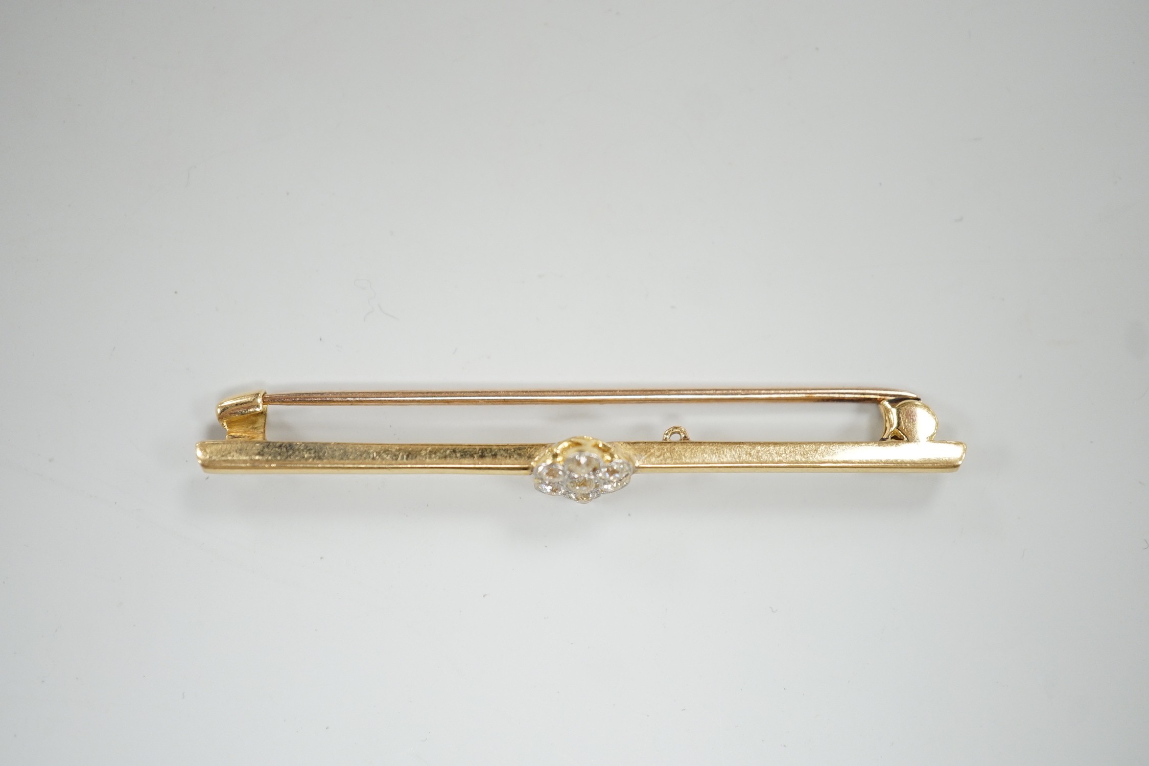 An 18ct and seven stone diamond set flower head cluster bar brooch, 57mm, gross weight 4.7 grams.